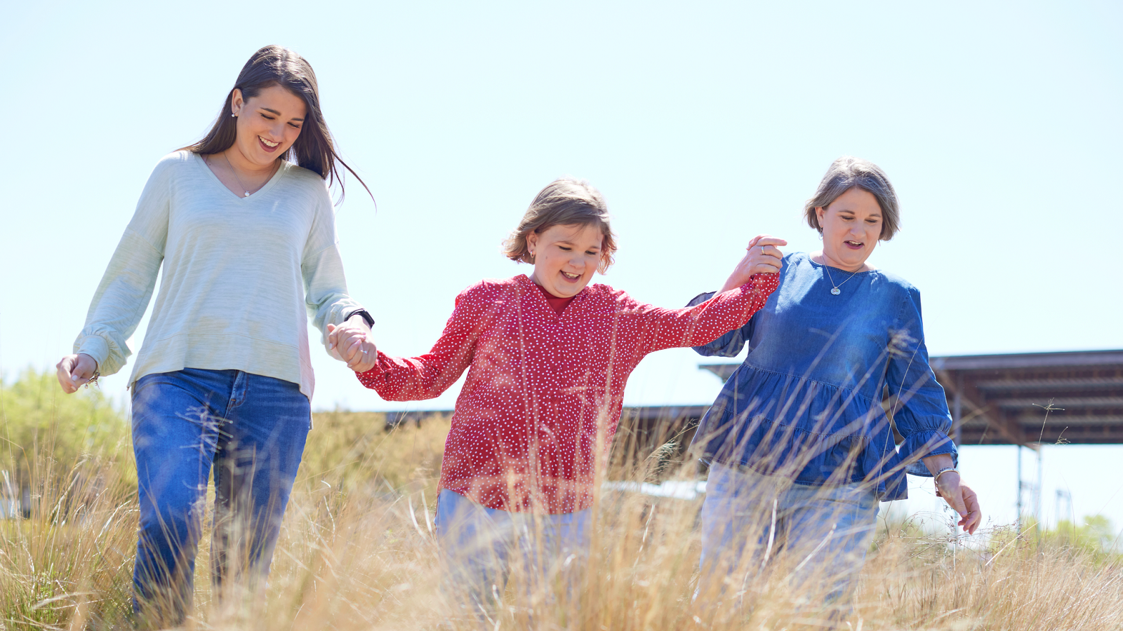 Picture of a mother frolicking outside with her two daughters
